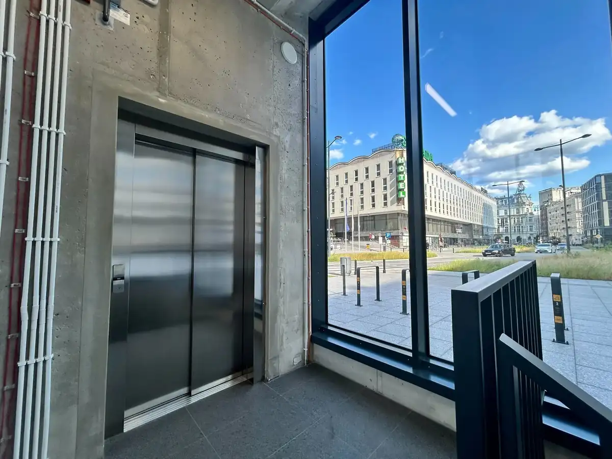 Parking Plac Powstańców Warszawy - winda prowadząca bezpośrednio na poziom placu, widok na centrum Warszawy i Hotel Warszawa